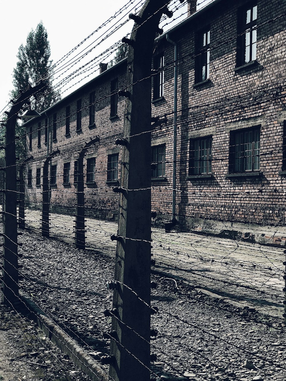 a brick building behind a barbed wire fence