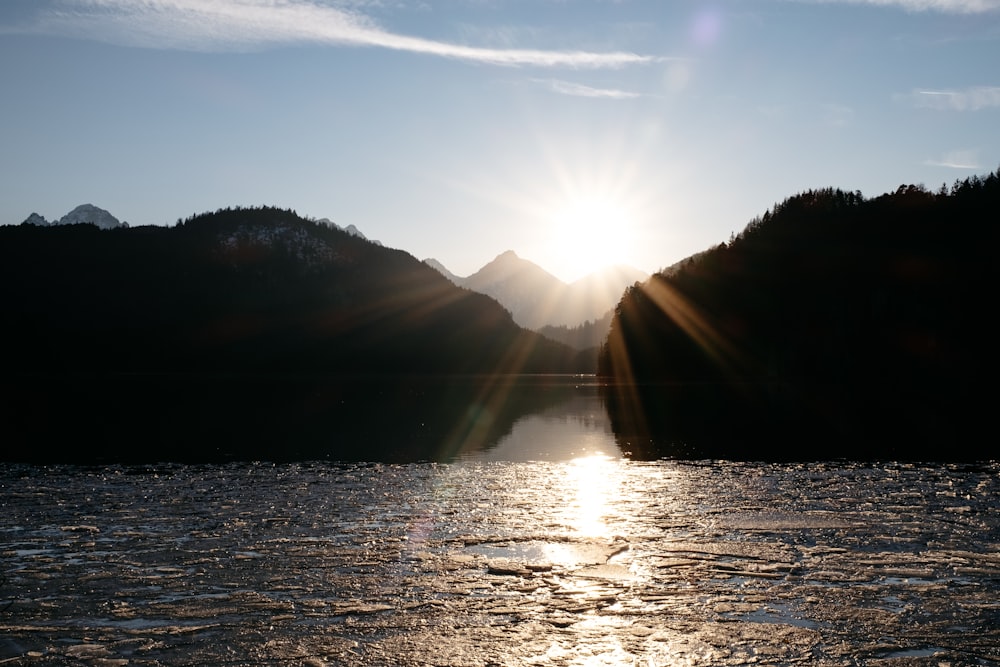 the sun is shining over a mountain range