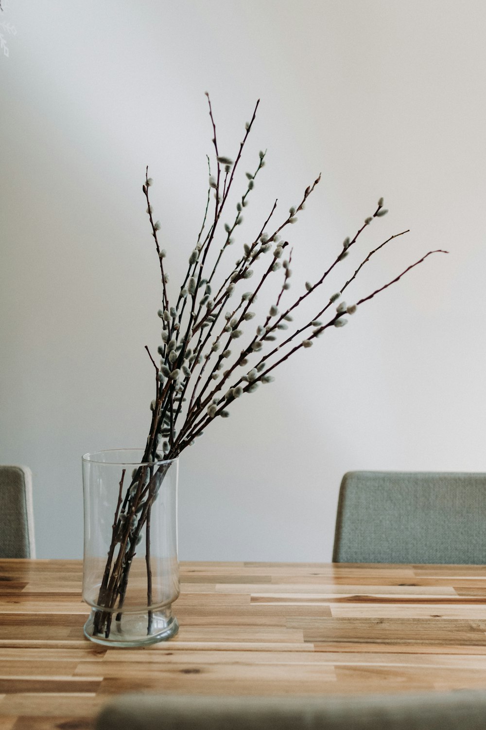 Foto Un jarrón lleno de ramas encima de una mesa de madera – Imagen Gris  gratis en Unsplash