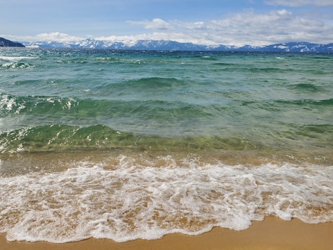 a view of the ocean with mountains in the distance
