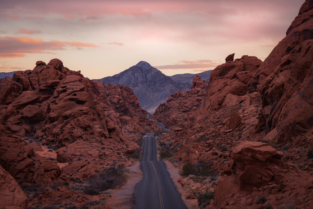 a road in the middle of a desert with mountains in the background