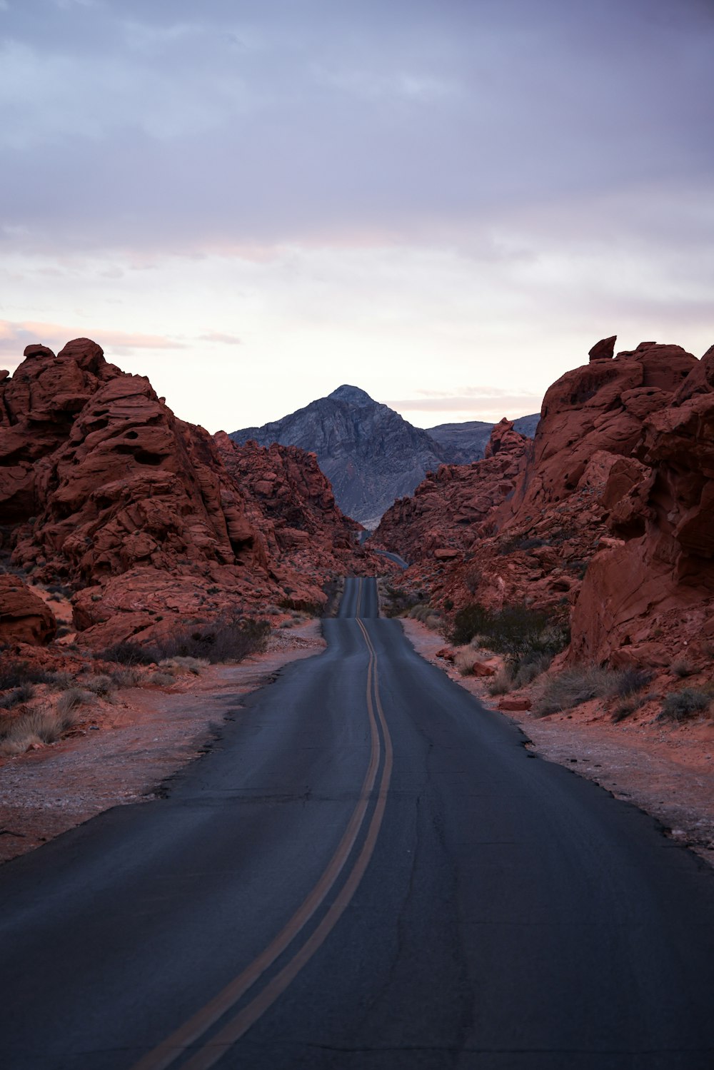 Un camino en medio de un desierto con montañas al fondo