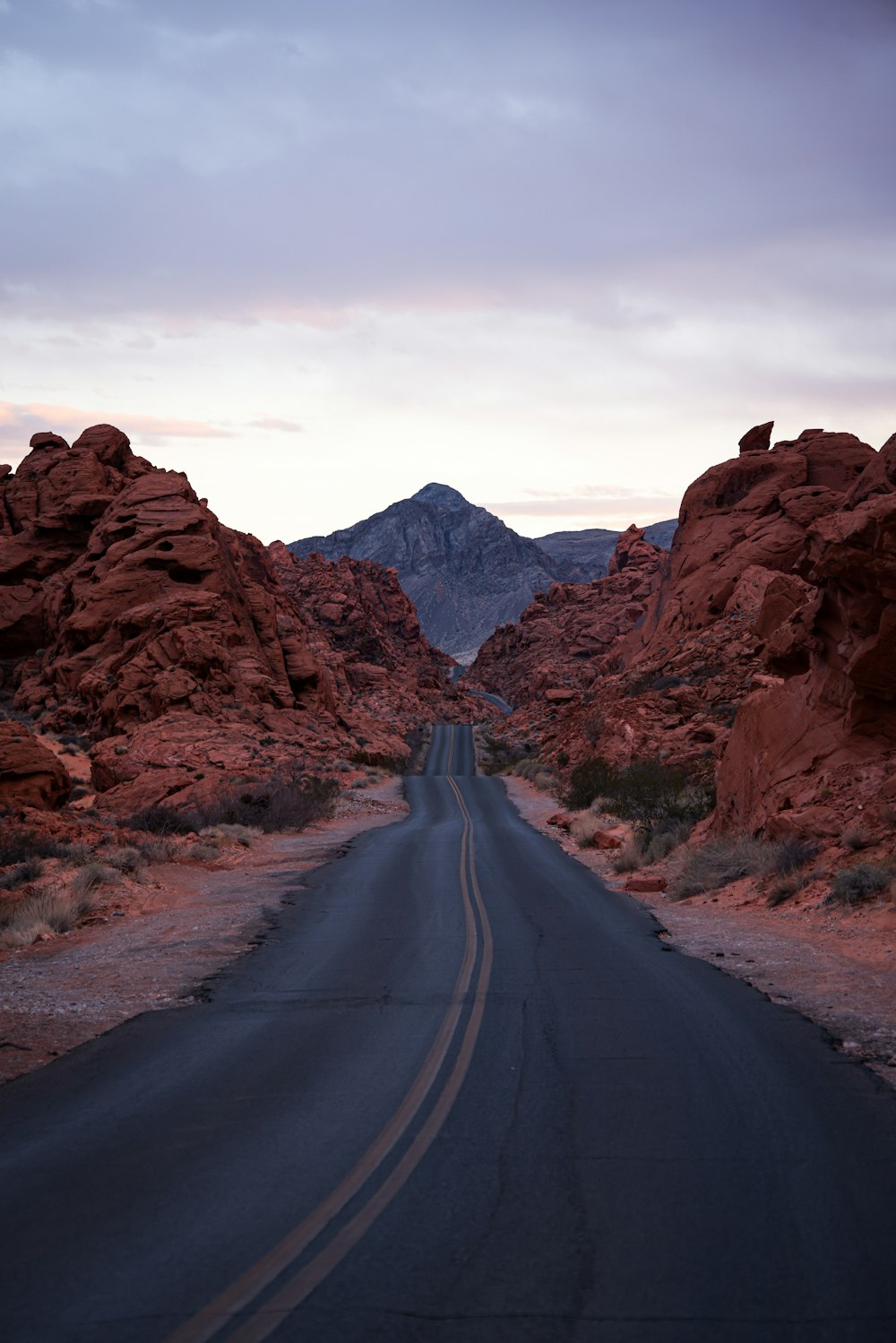 a road in the middle of a desert with mountains in the background