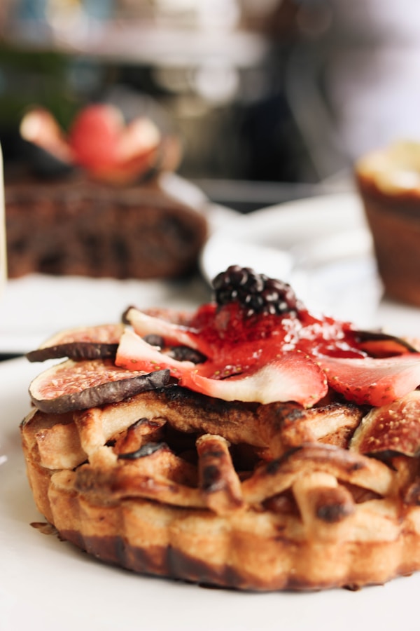 A stack of waffles with fruit on top