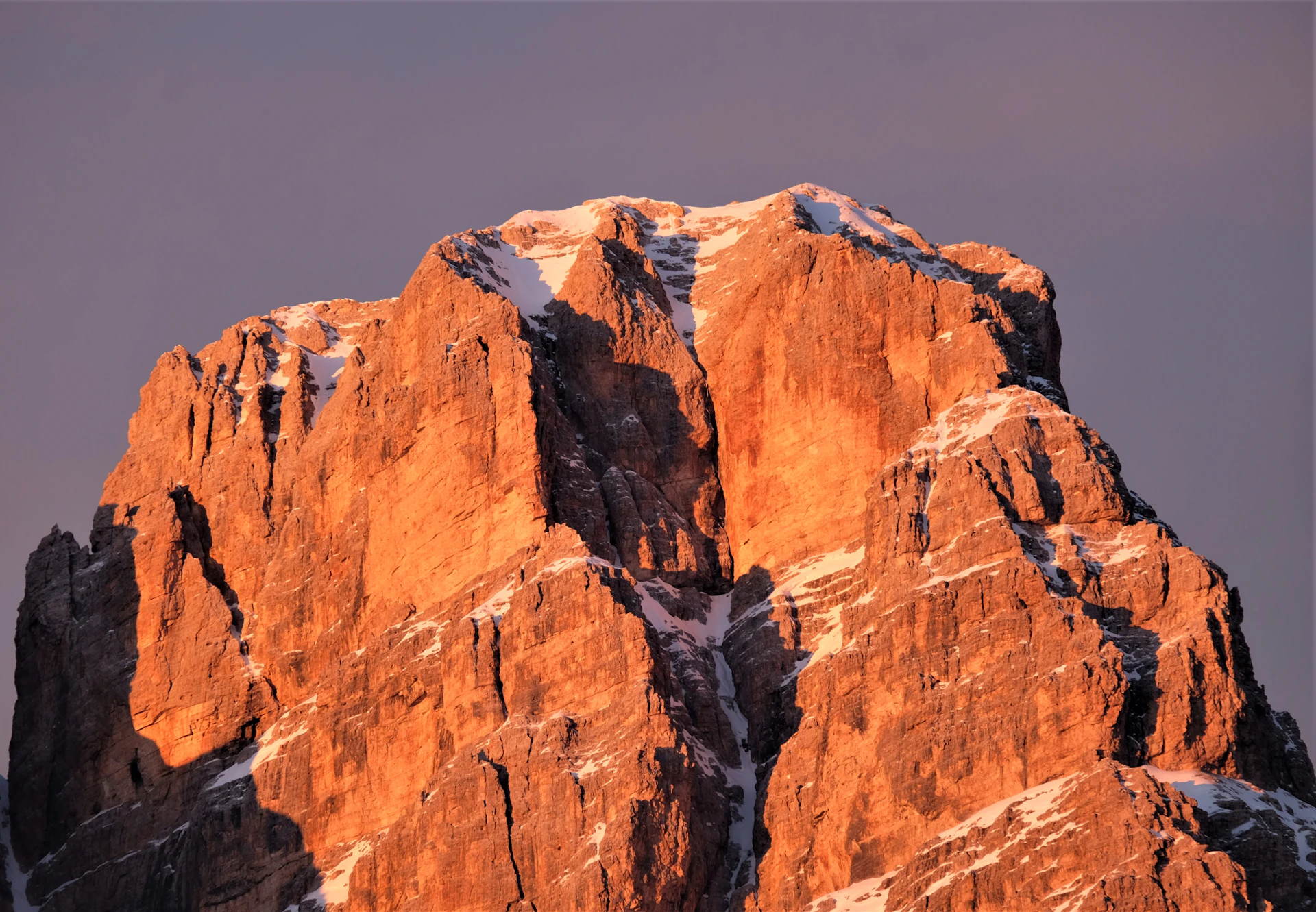 A dramatic mountain peak at dawn, bathed in soft golden light, capturing the spirit of adventure and exploration.