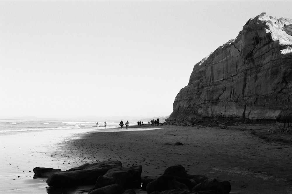 a group of people standing on top of a sandy beach