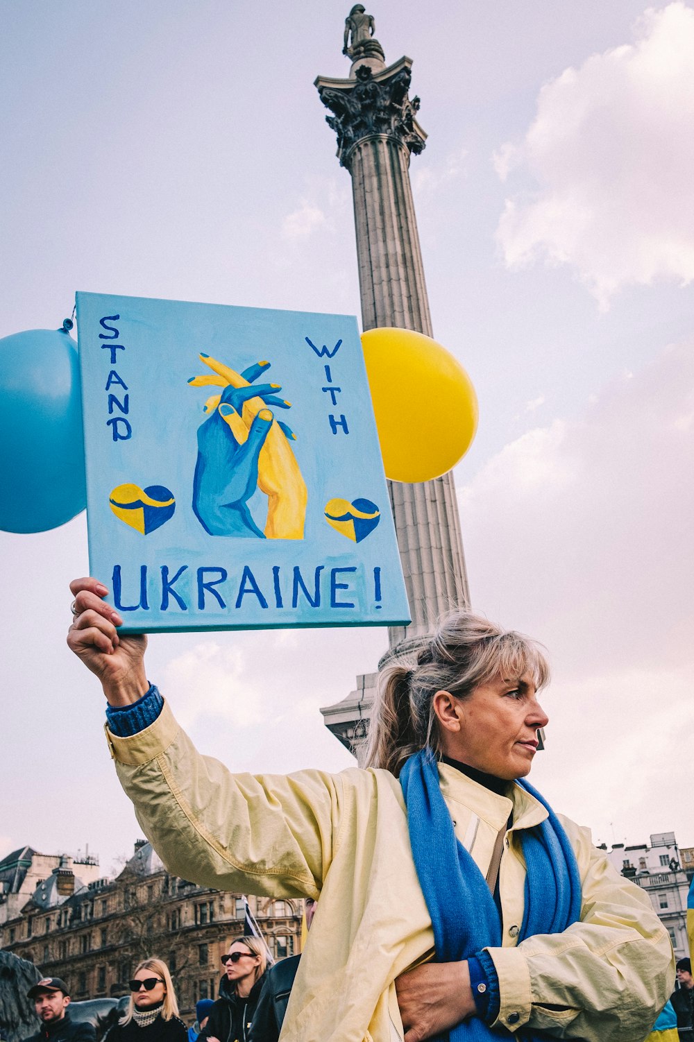 a woman holding a sign that says ukraine