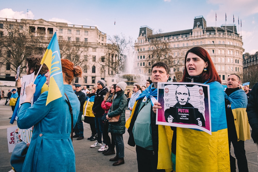 a group of people standing around each other holding signs