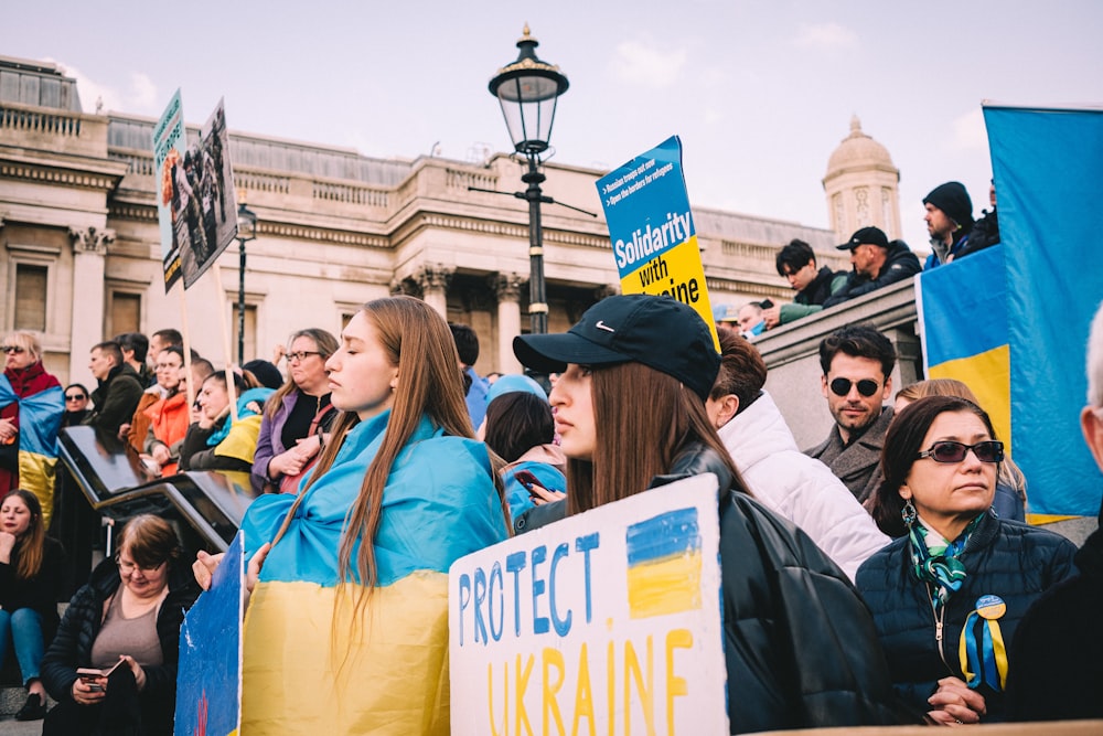 a group of people holding signs in front of a building