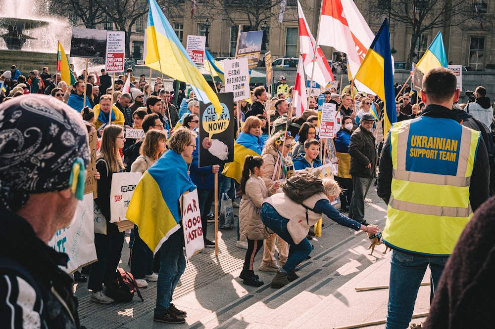a crowd of people holding flags and signs