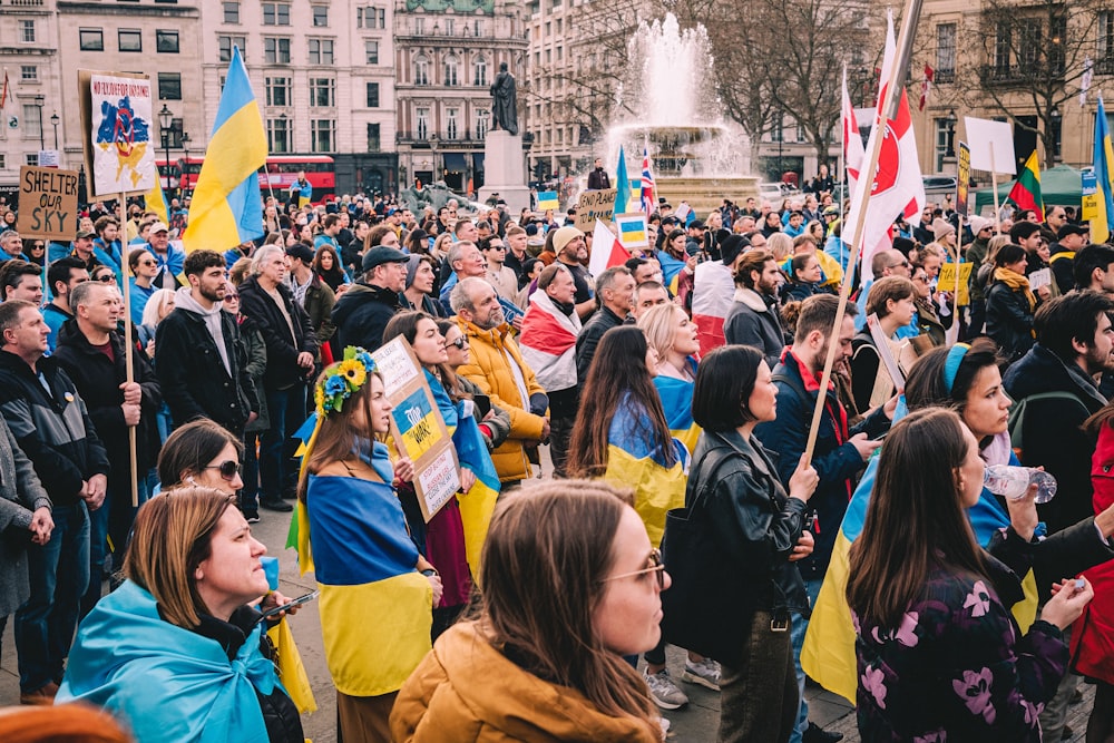 a large group of people holding flags and signs