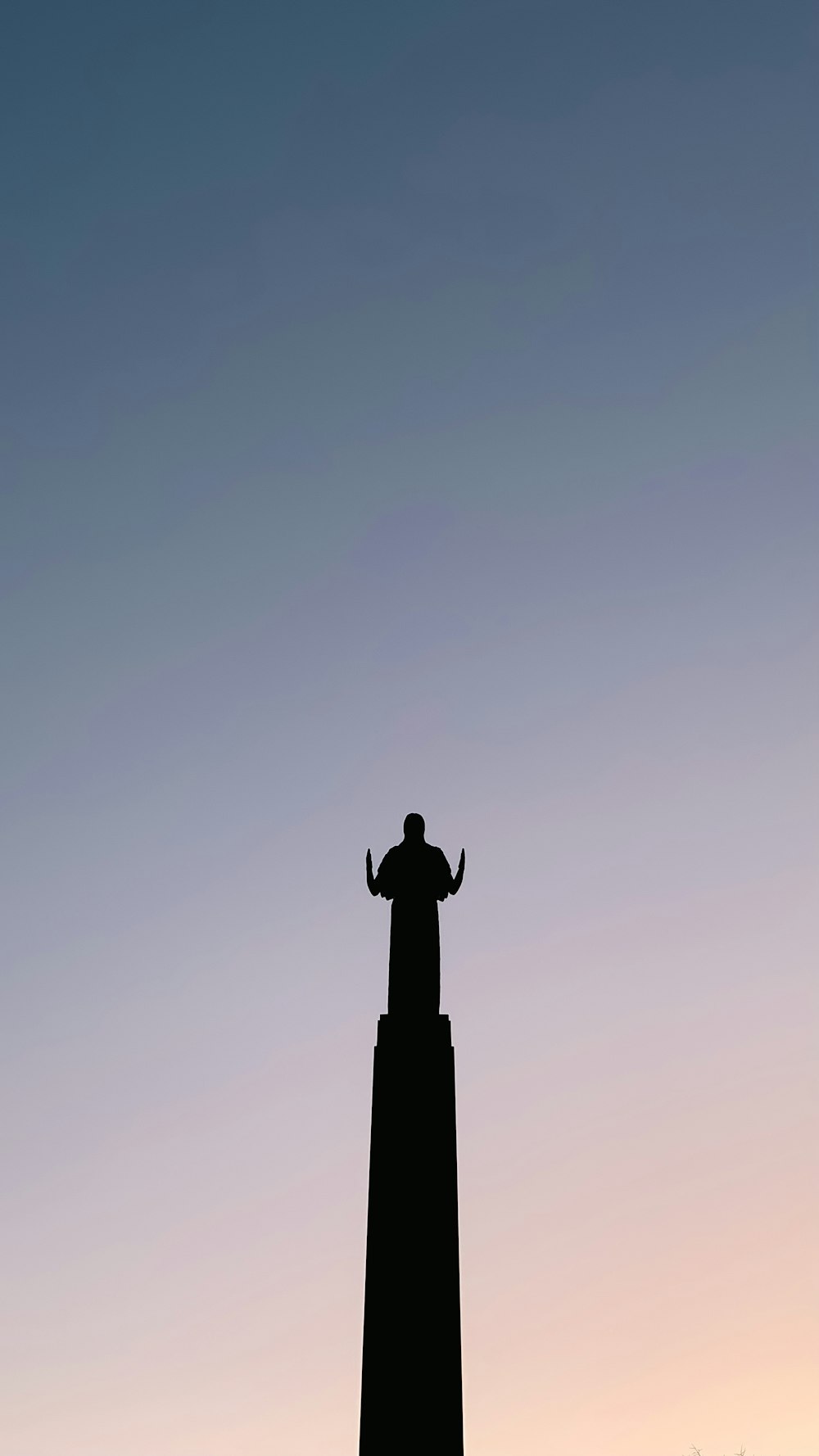 a silhouette of a person standing on top of a tower