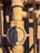A close-up view of a metal valve with an open and off lever set against a textured wall. The valve appears rusty and weathered, indicating age and exposure to the elements.