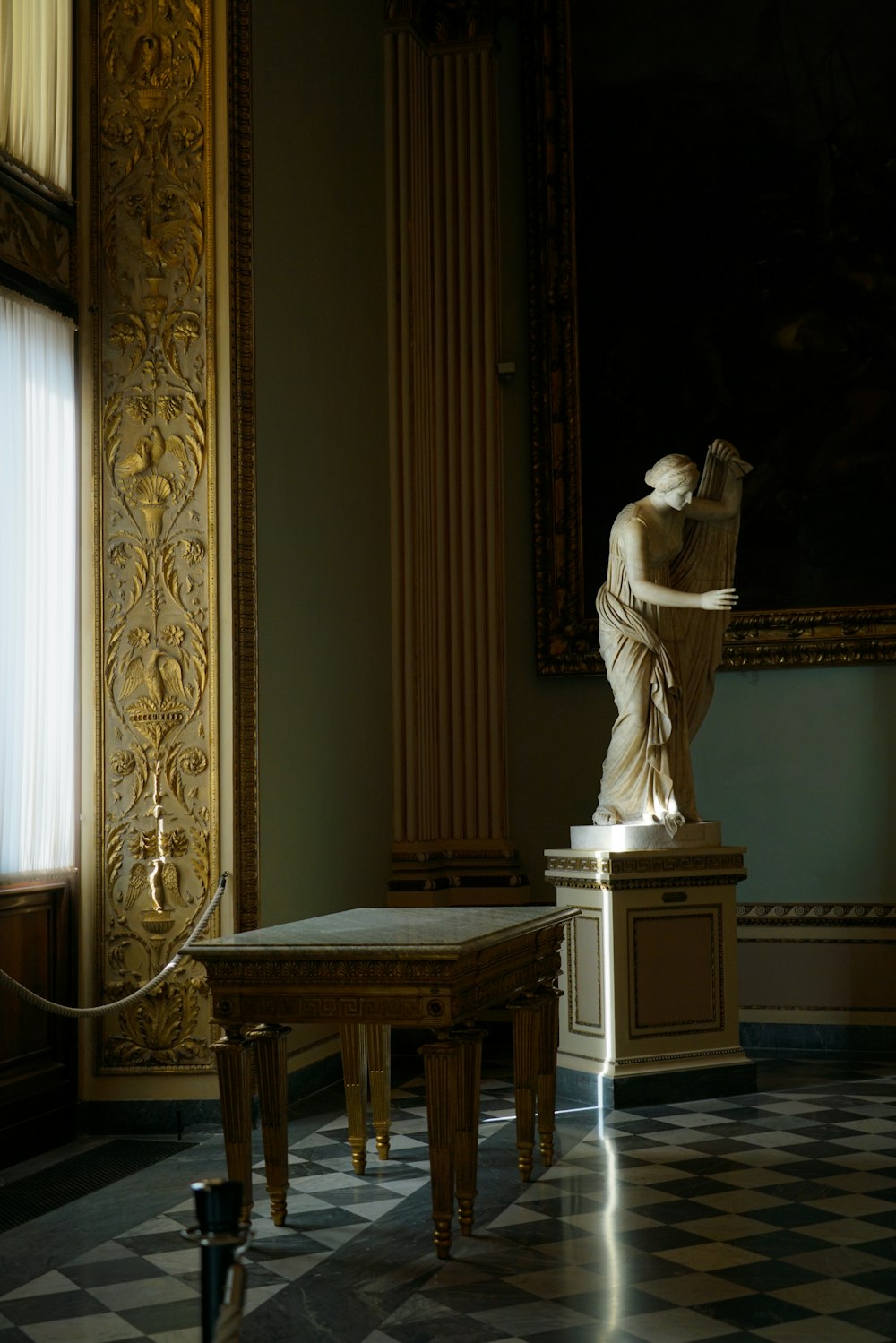 a statue of a woman in a room with a checkered floor
