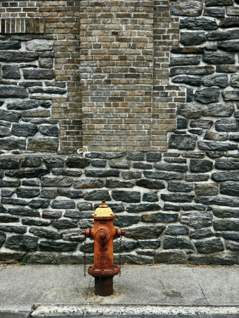 a red and yellow fire hydrant sitting on the side of a road