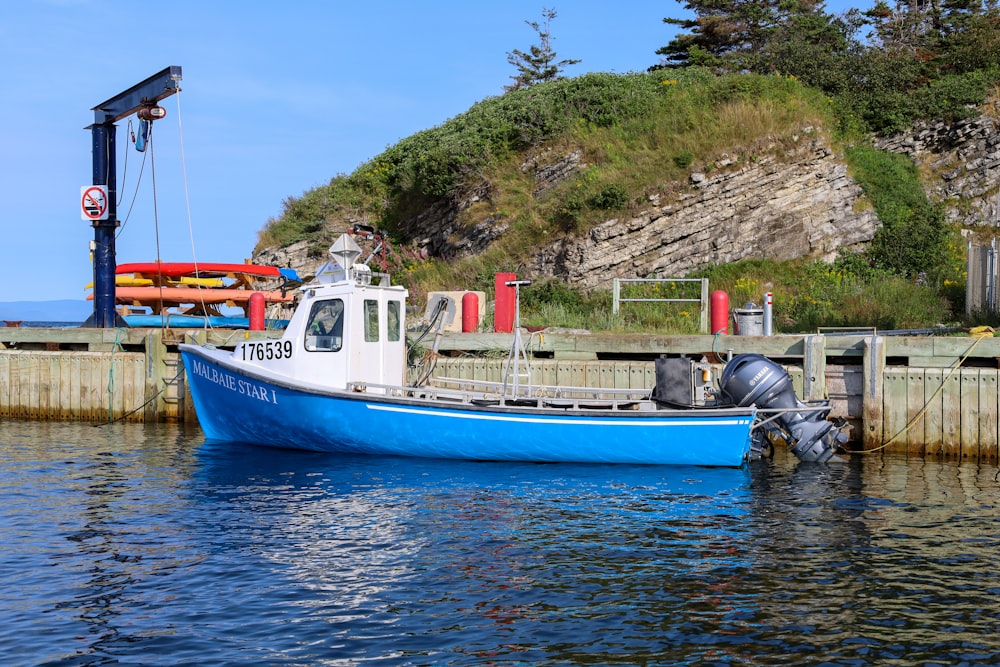 a blue and white boat docked at a dock