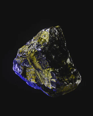 a blue and yellow rock on a black background