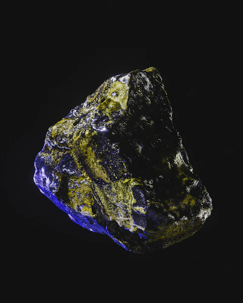 a blue and yellow rock on a black background