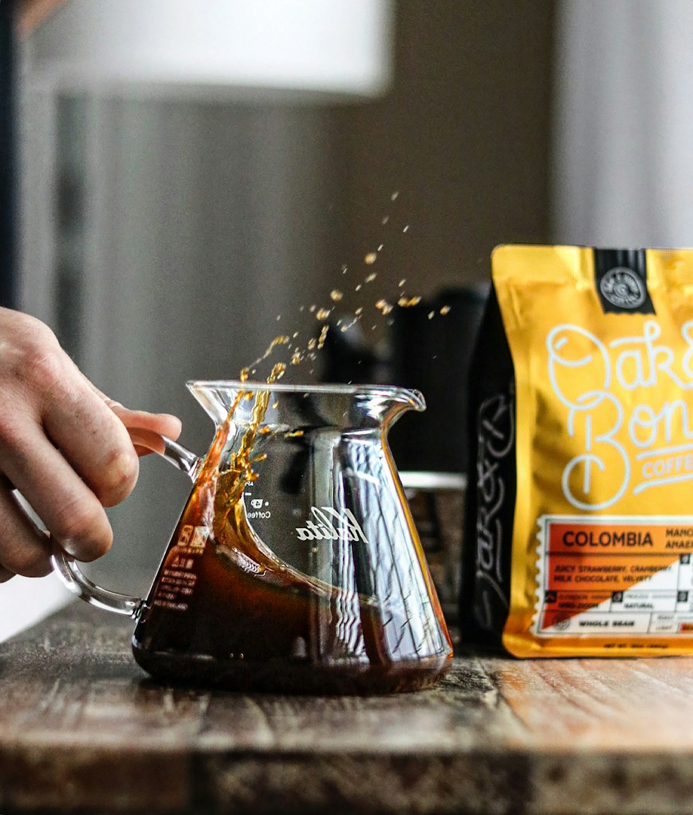 a person pours coffee into a coffee pot