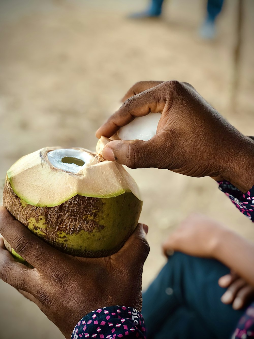 a person holding a coconut in their hand