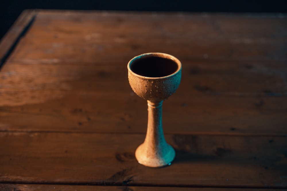 una piccola tazza seduta sopra un tavolo di legno