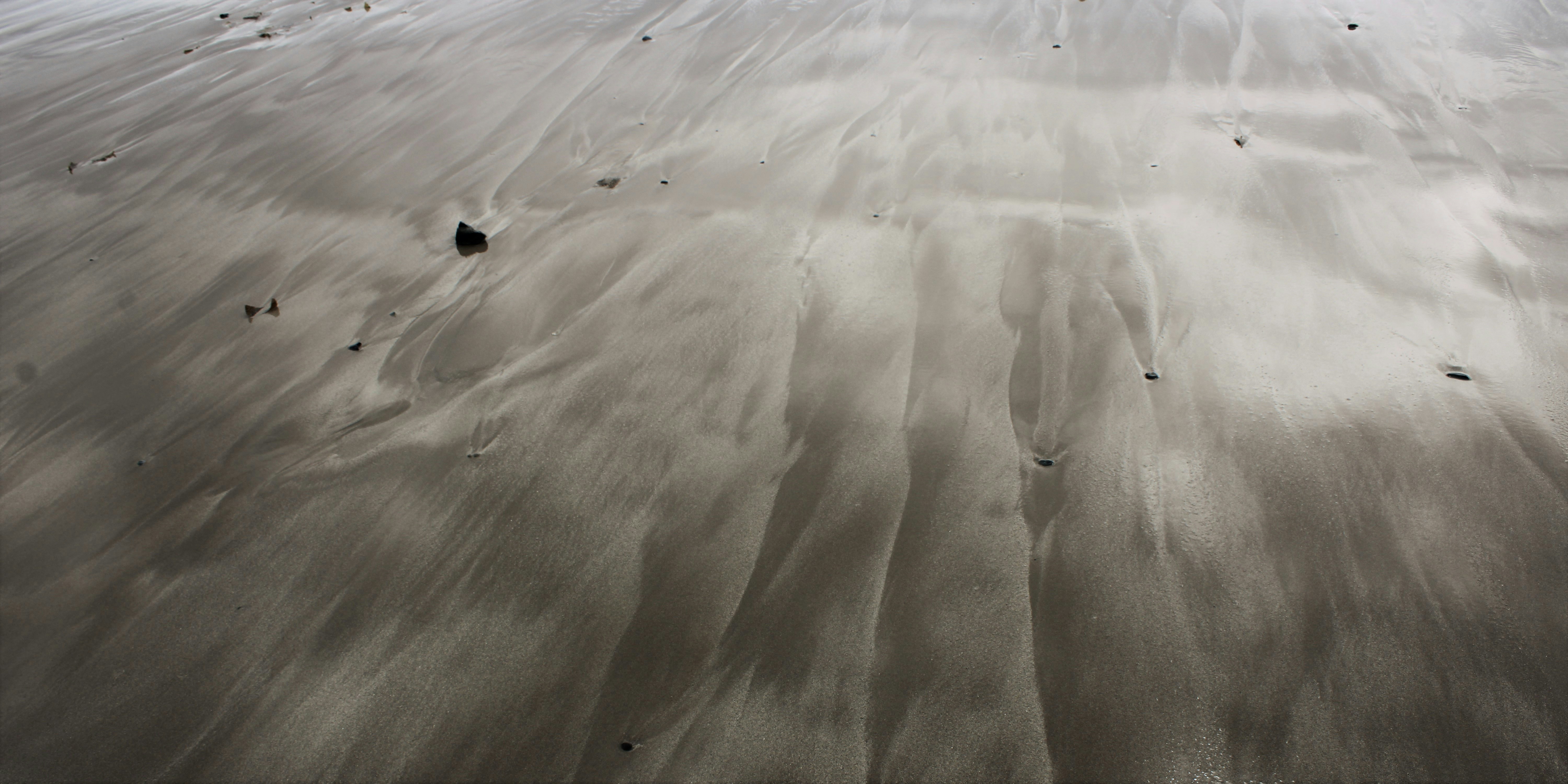 a sandy beach with footprints in the sand