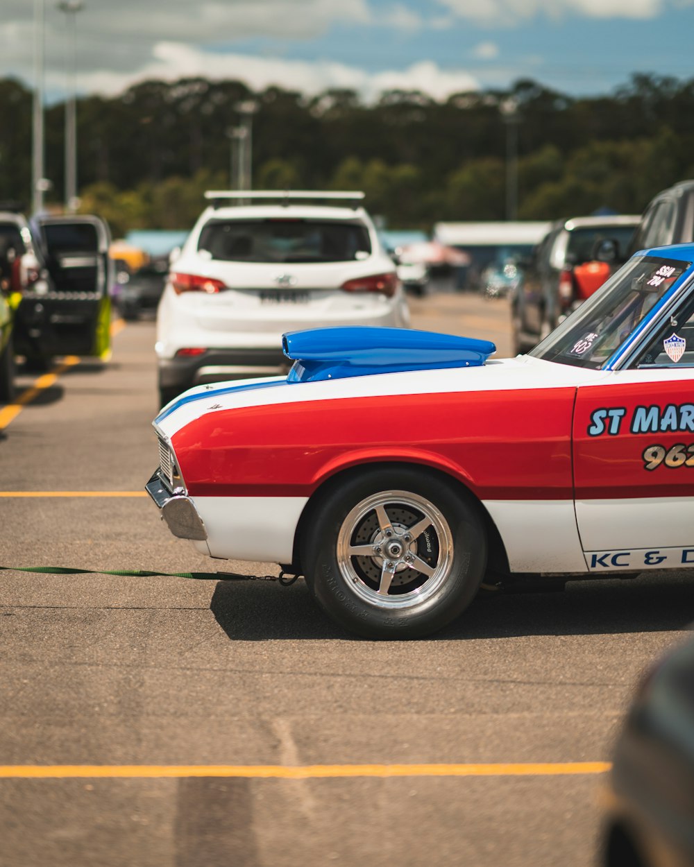 a red, white and blue car parked in a parking lot