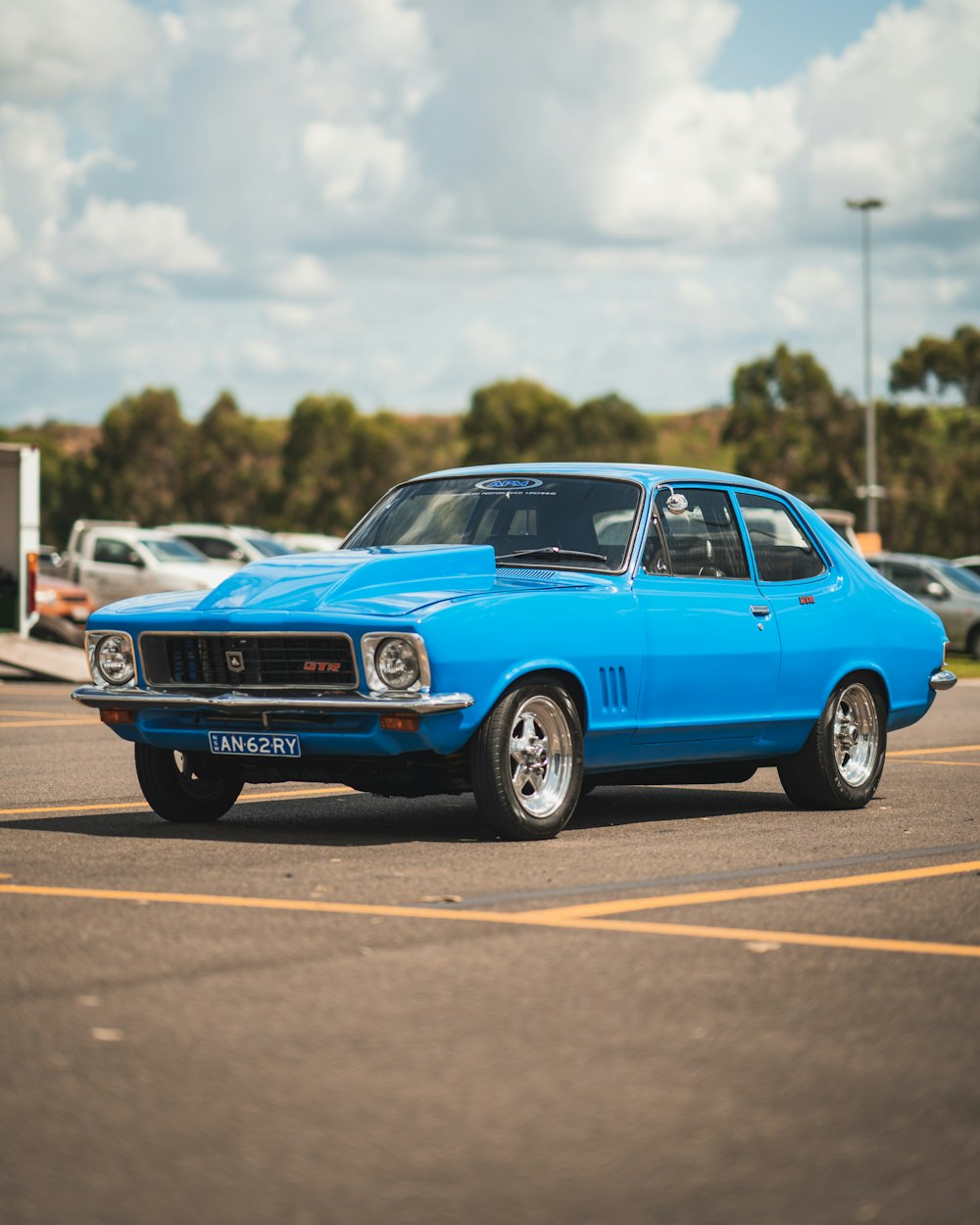 a blue car is parked in a parking lot