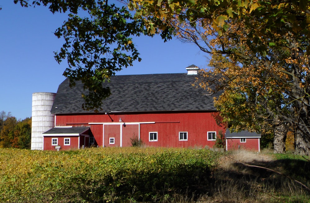 a red barn with a silo in the background