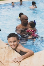 A friendly swimming instructor scheduling a lesson with a parent and child at the poolside