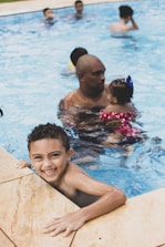 A child learning to swim with instructor in a pool