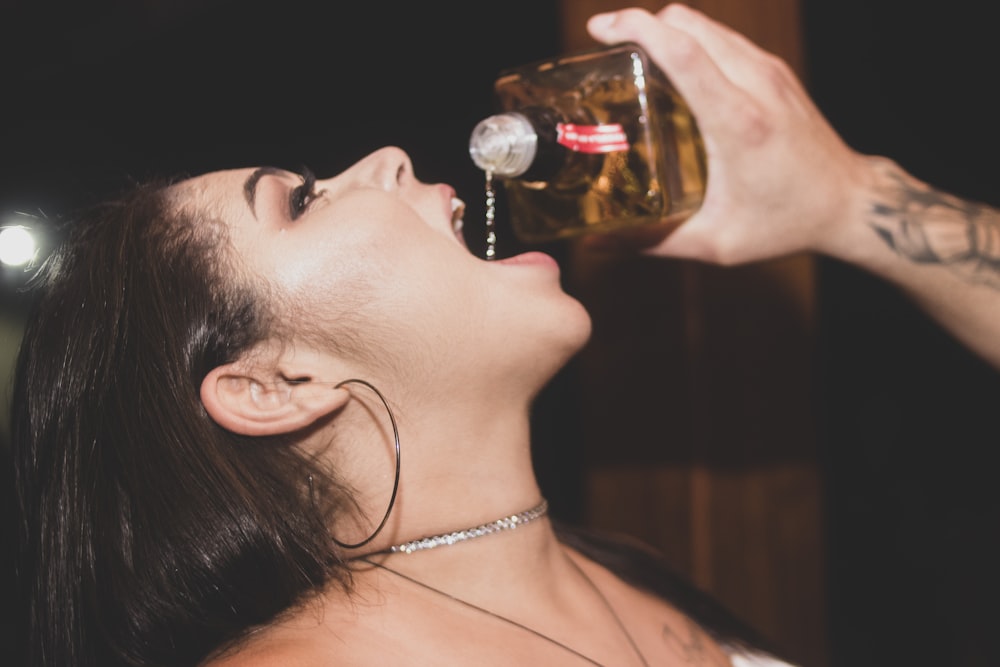 a woman drinking a beer from a bottle