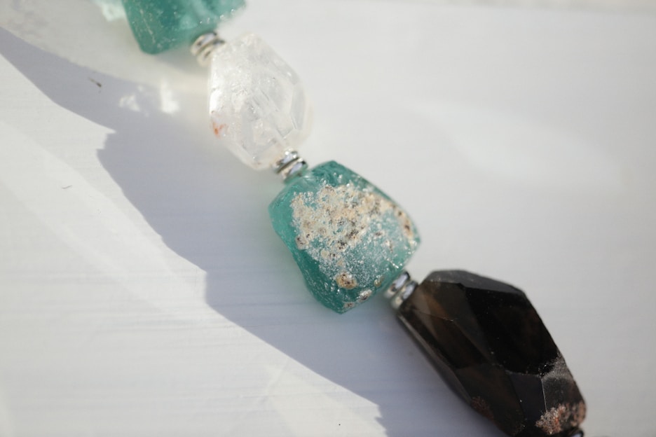 Close-up of authentic 3 mukhi rudraksha beads resting on natural kraft paper with soft sunlight highlighting their texture.
