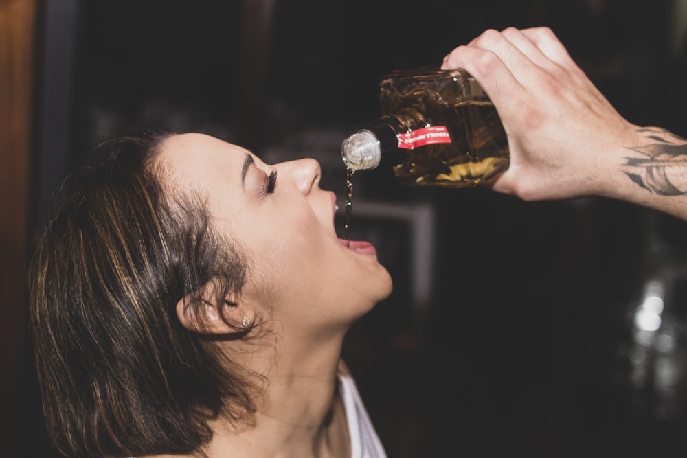 a woman drinking a beer from a bottle