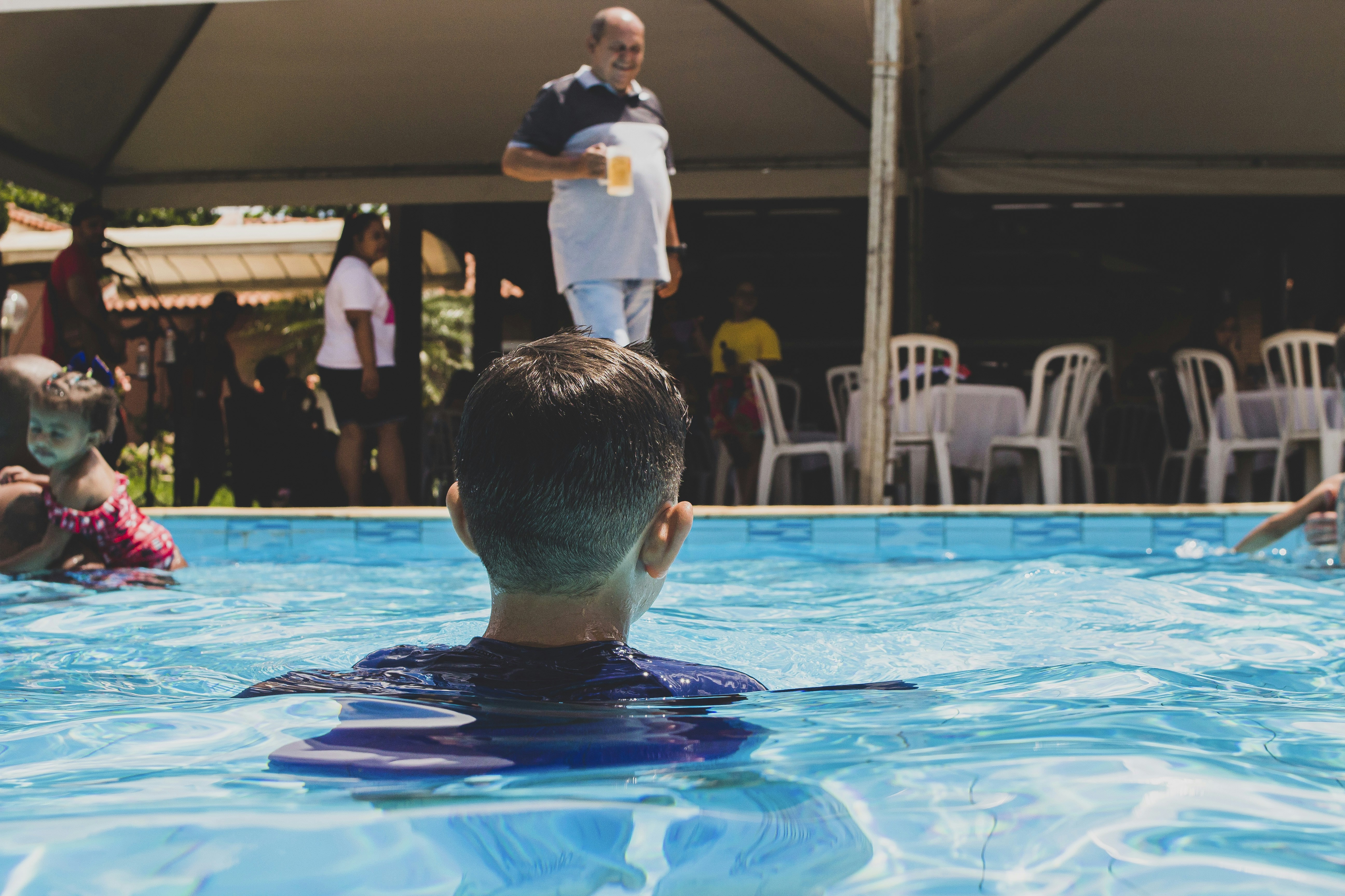 a man in a swimming pool with people in the background