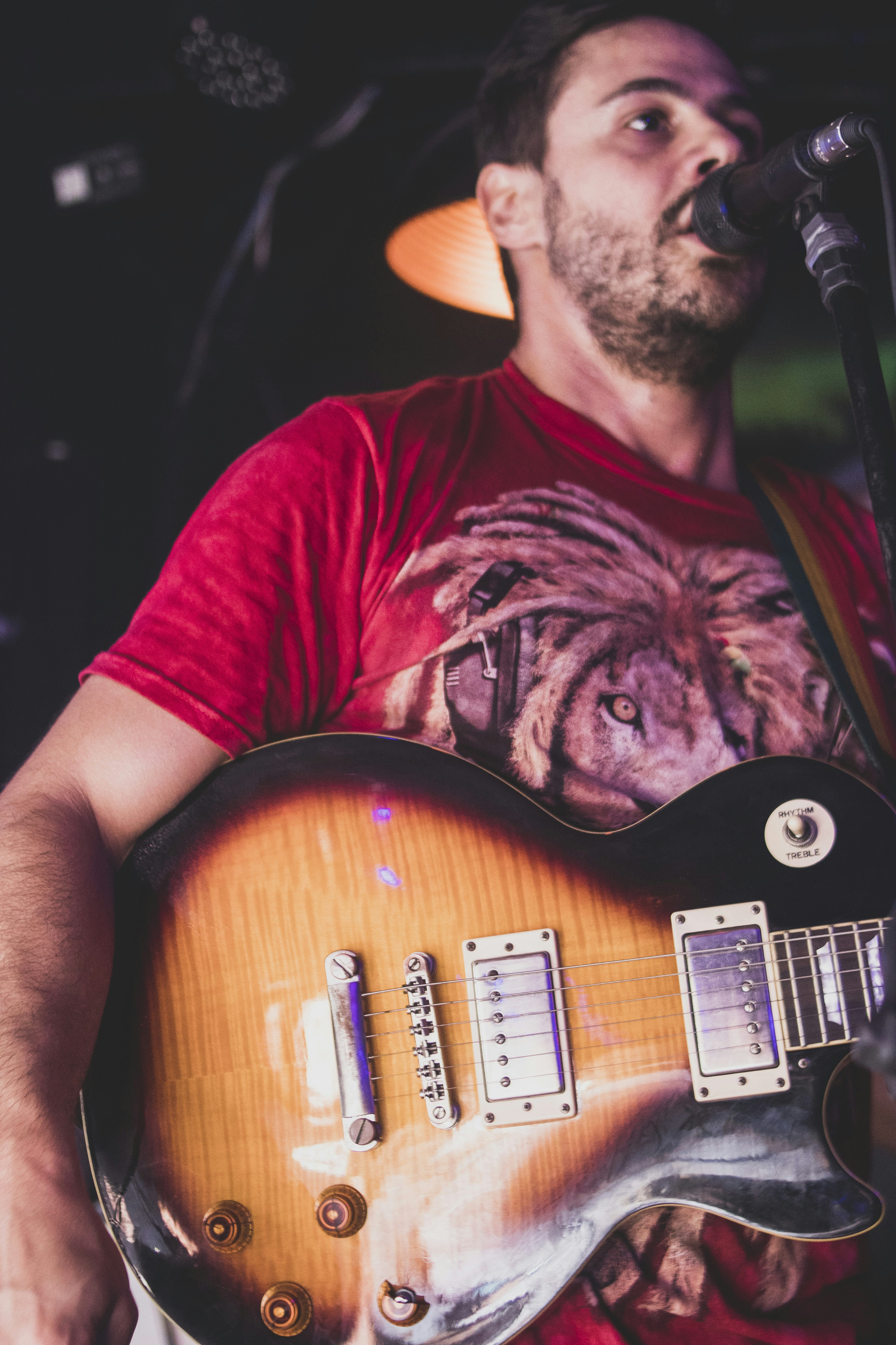 a man holding a guitar while standing next to a microphone
