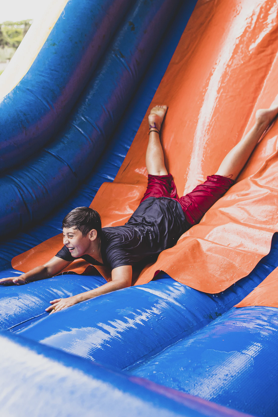 a young man sliding down an inflatable slide