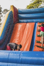 a boy and a girl playing in a bouncy castle