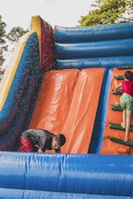 a boy and a girl playing in a bouncy castle