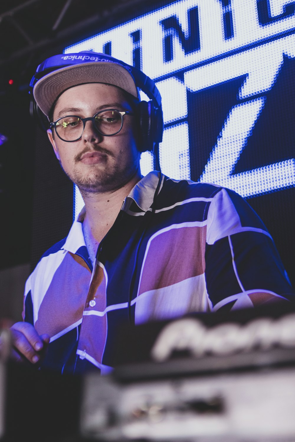 a man wearing headphones standing in front of a stage