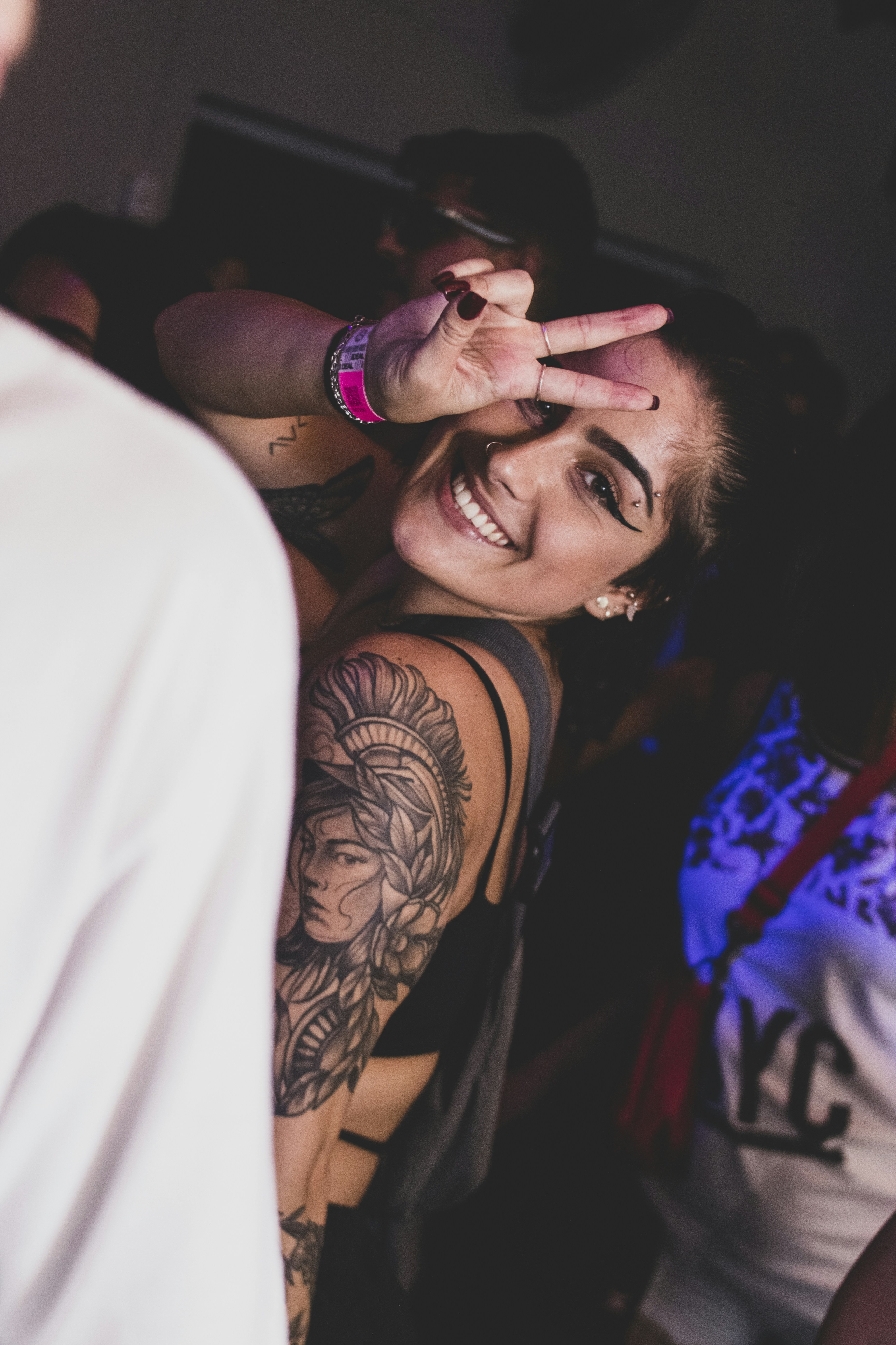 a woman with a tattoo on her arm making a peace sign