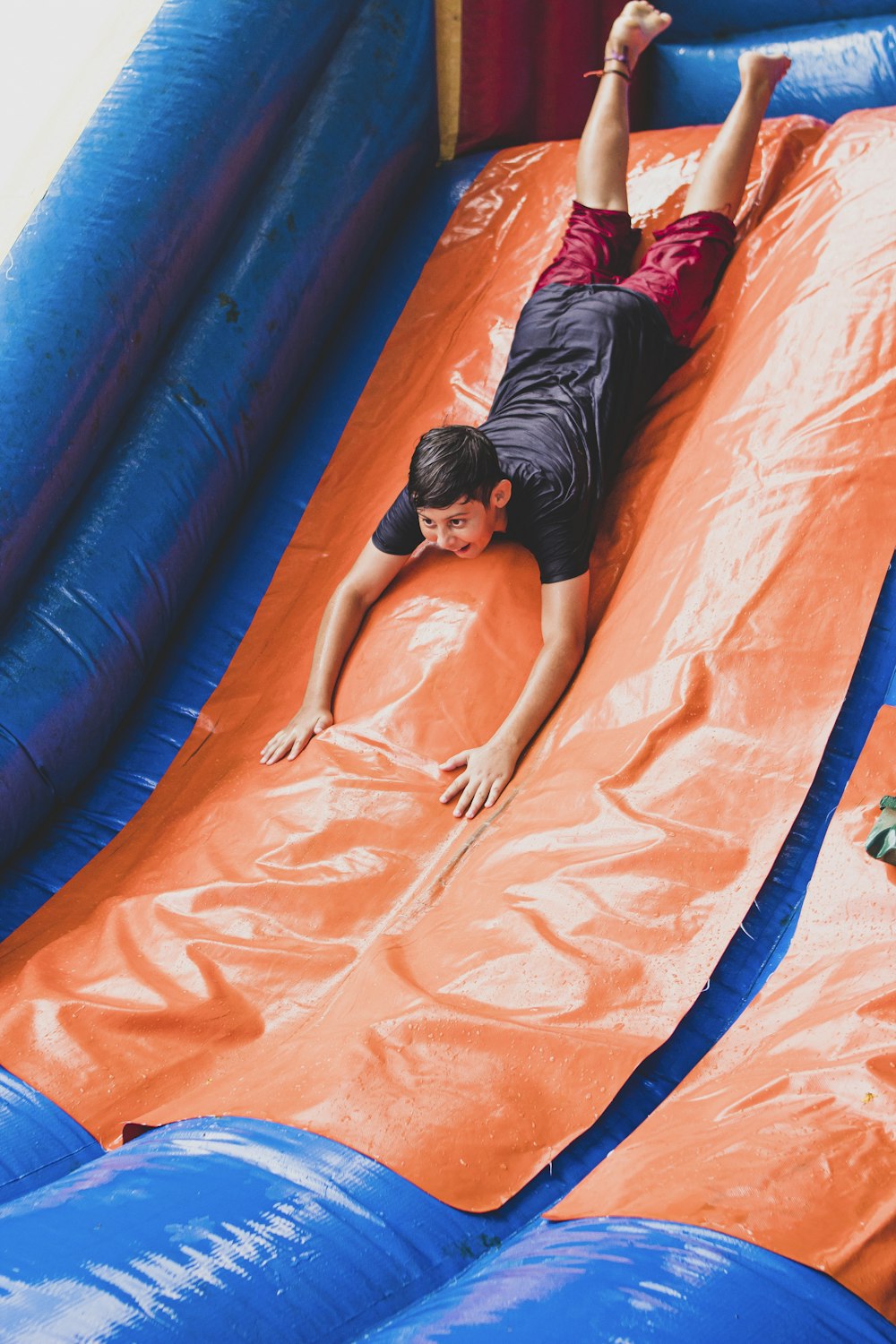 a young boy sliding down an inflatable slide