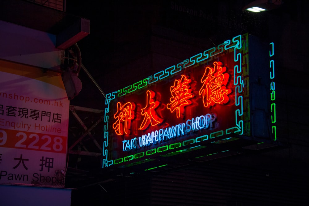 a neon sign is lit up in the dark