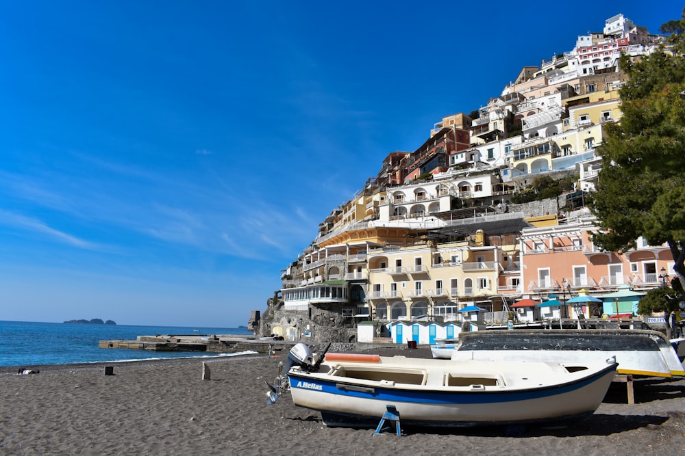 a boat on a beach near a city