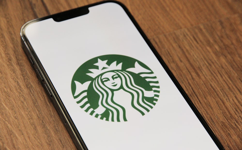 a close up of a cell phone with a starbucks logo on it