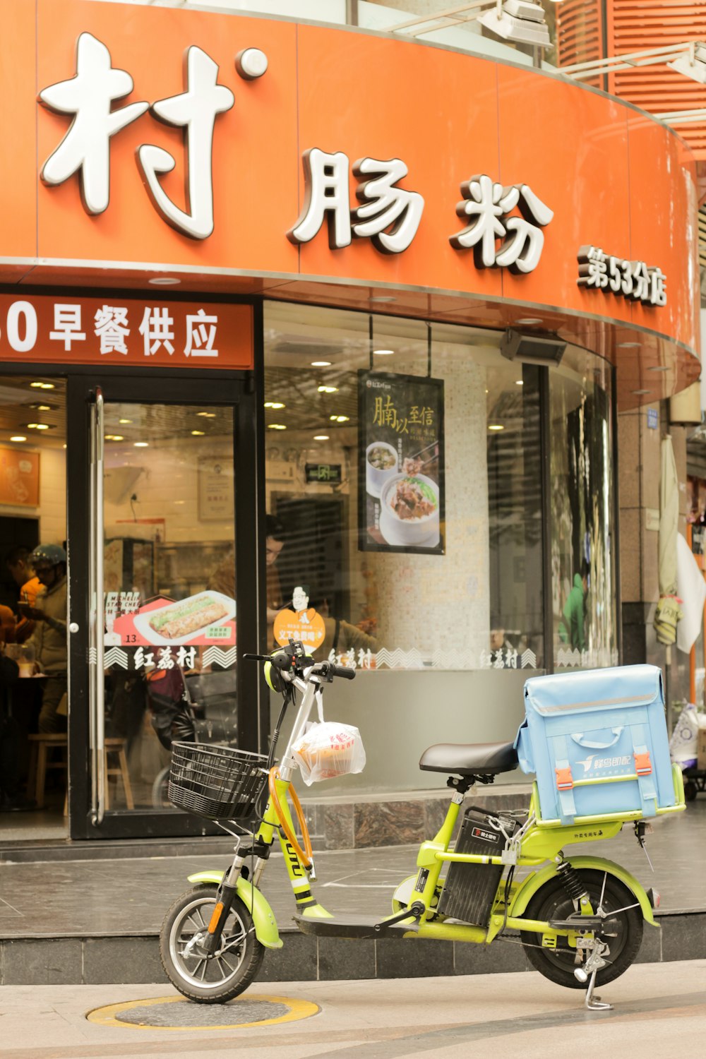 a yellow scooter parked in front of a chinese restaurant