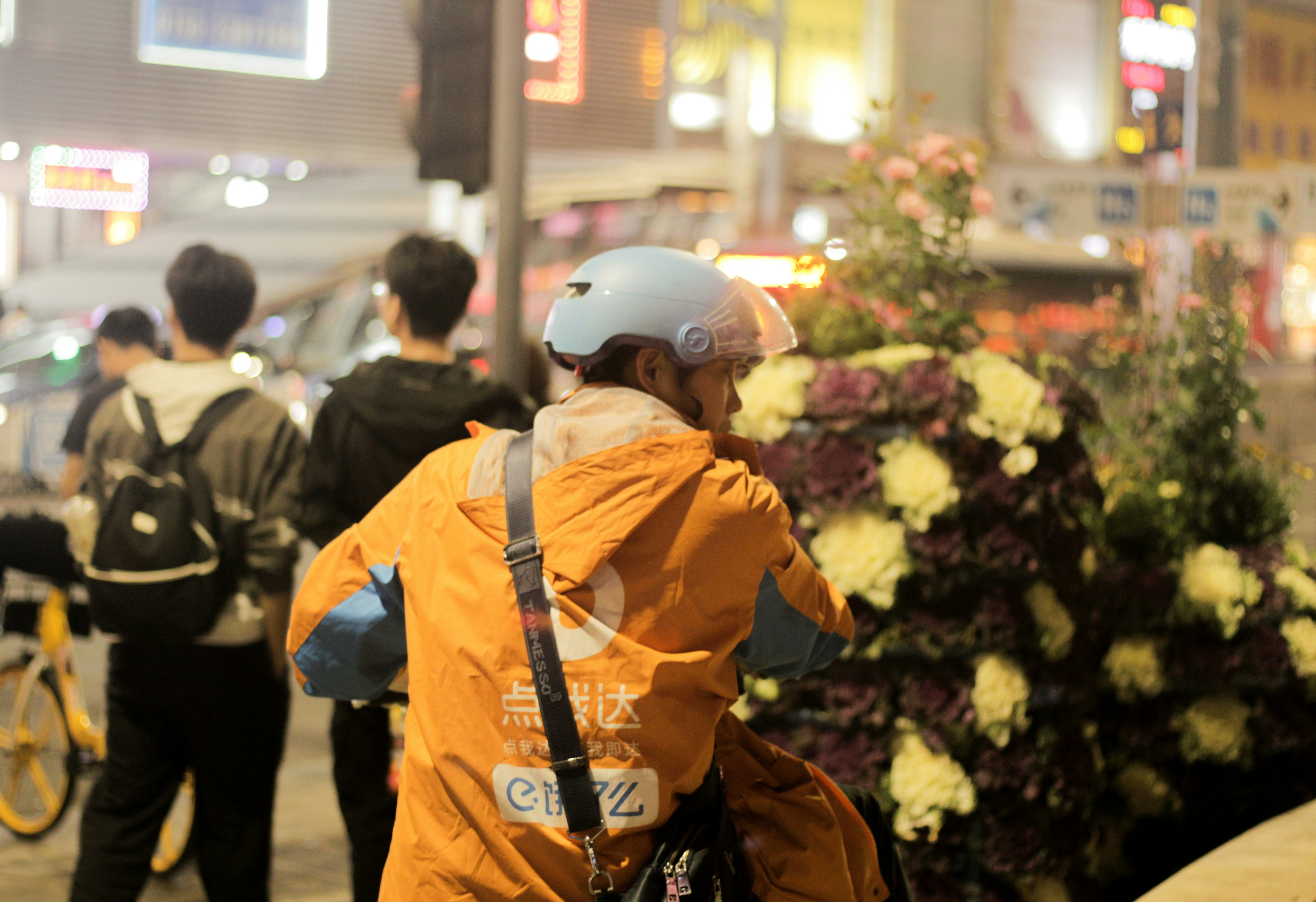 a group of people walking down a street at night
