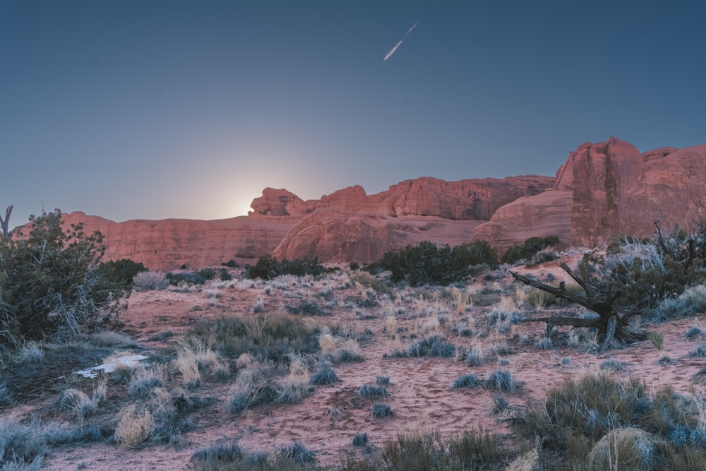 the sun is setting over a desert landscape