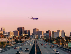 an airplane is flying over a busy highway
