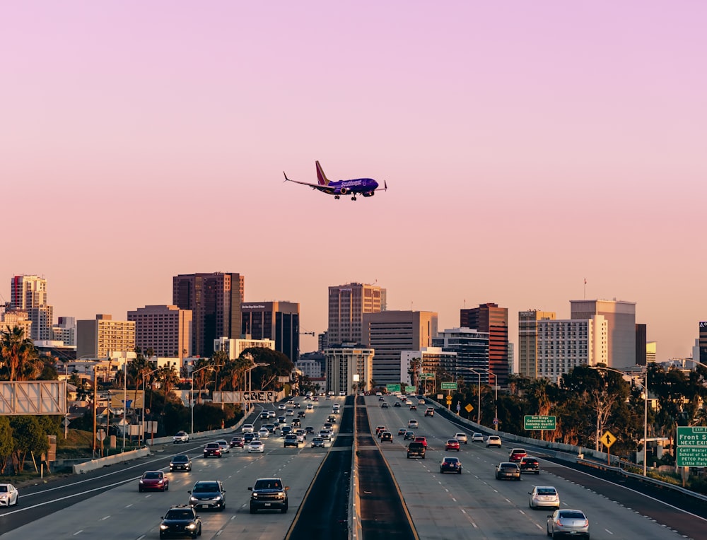 an airplane is flying over a busy highway